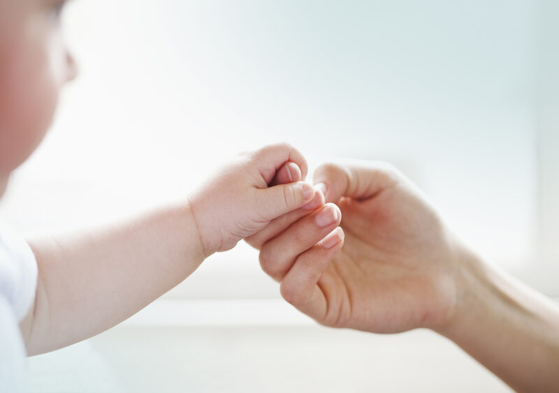 Mains de parent tenant celles d'un bébé
