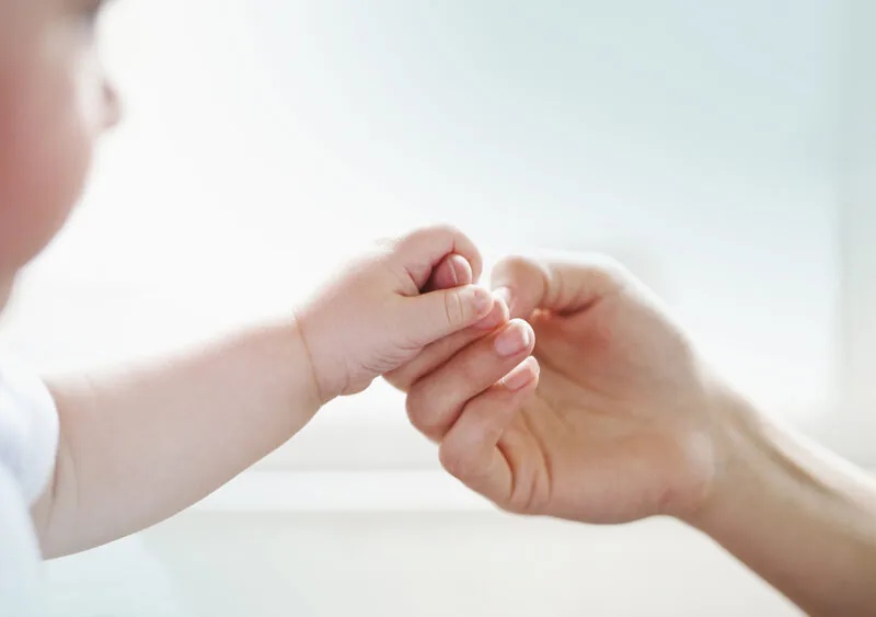 Mains de parent tenant celles d'un bébé